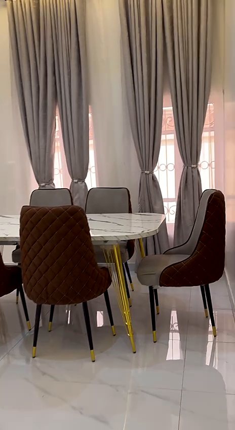 Marble dining table with quilted chairs on gold legs