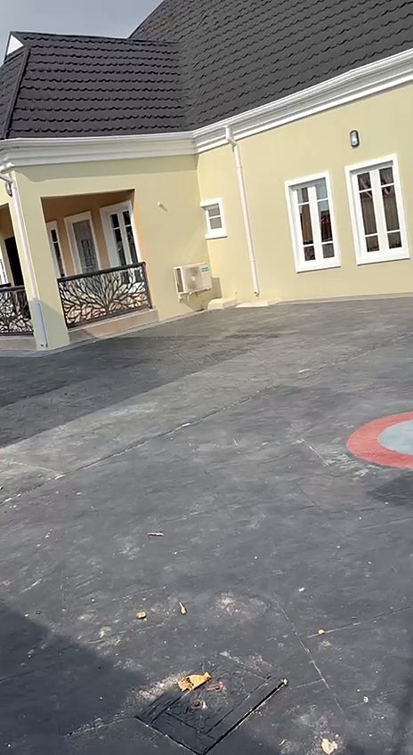 The bungalow and paved courtyard inside the gated compound