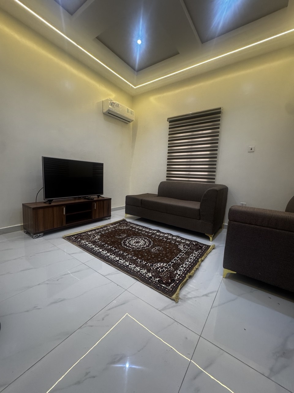 Sitting room with two grey sofas and a red Persian rug